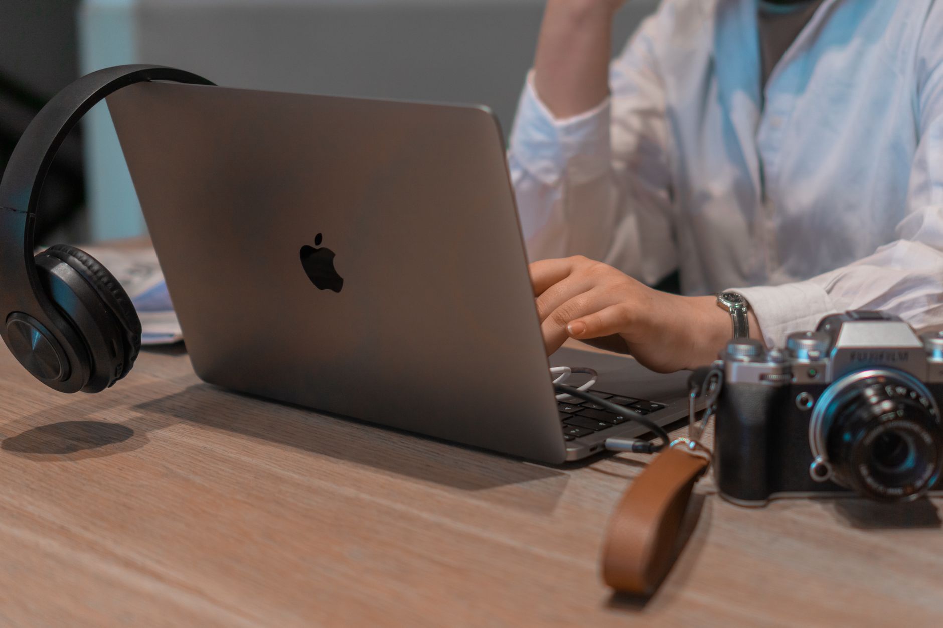 Photo : Beyzanur K. / Pexels Une personne travaille sur un ordinateur portable à un bureau clair, avec un carnet ouvert et une tasse de café posés à côté